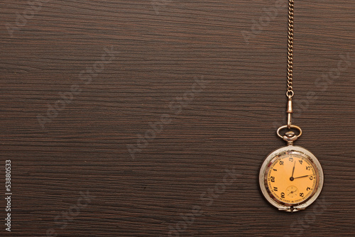 Photo of silver vintage pocket watch with chain on wooden backgr