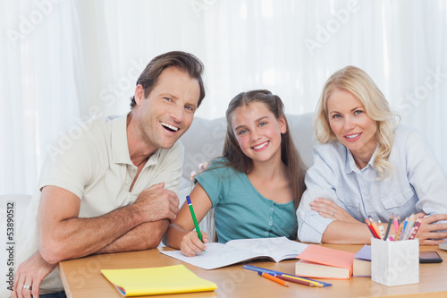 Parents helping her daughter to do her homework