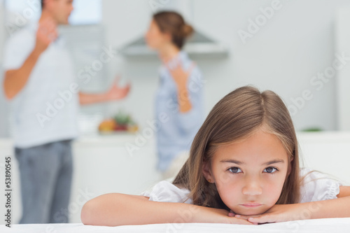 Upset girl listening to parents quarreling