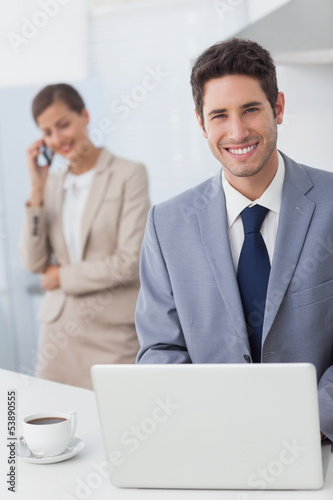 Happy businessman using a laptop before going to work