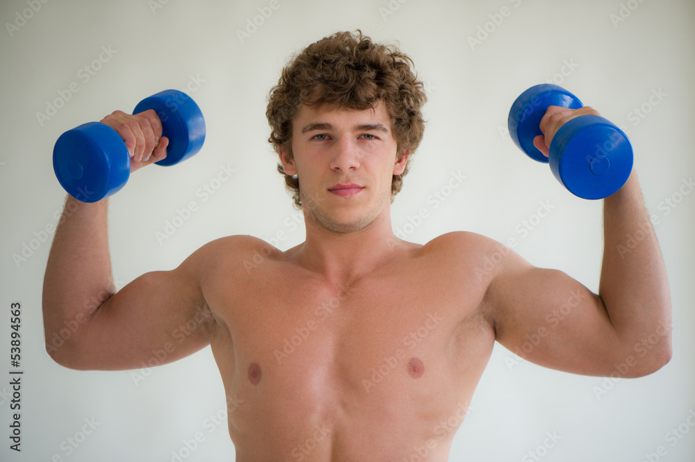 young man does exercises with dumbbells young man does exercises with dumbbells