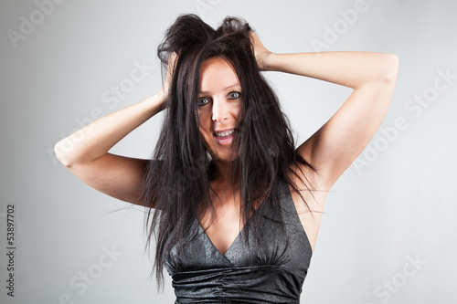 Frau rauft sich die Haare und blickt erschrocken