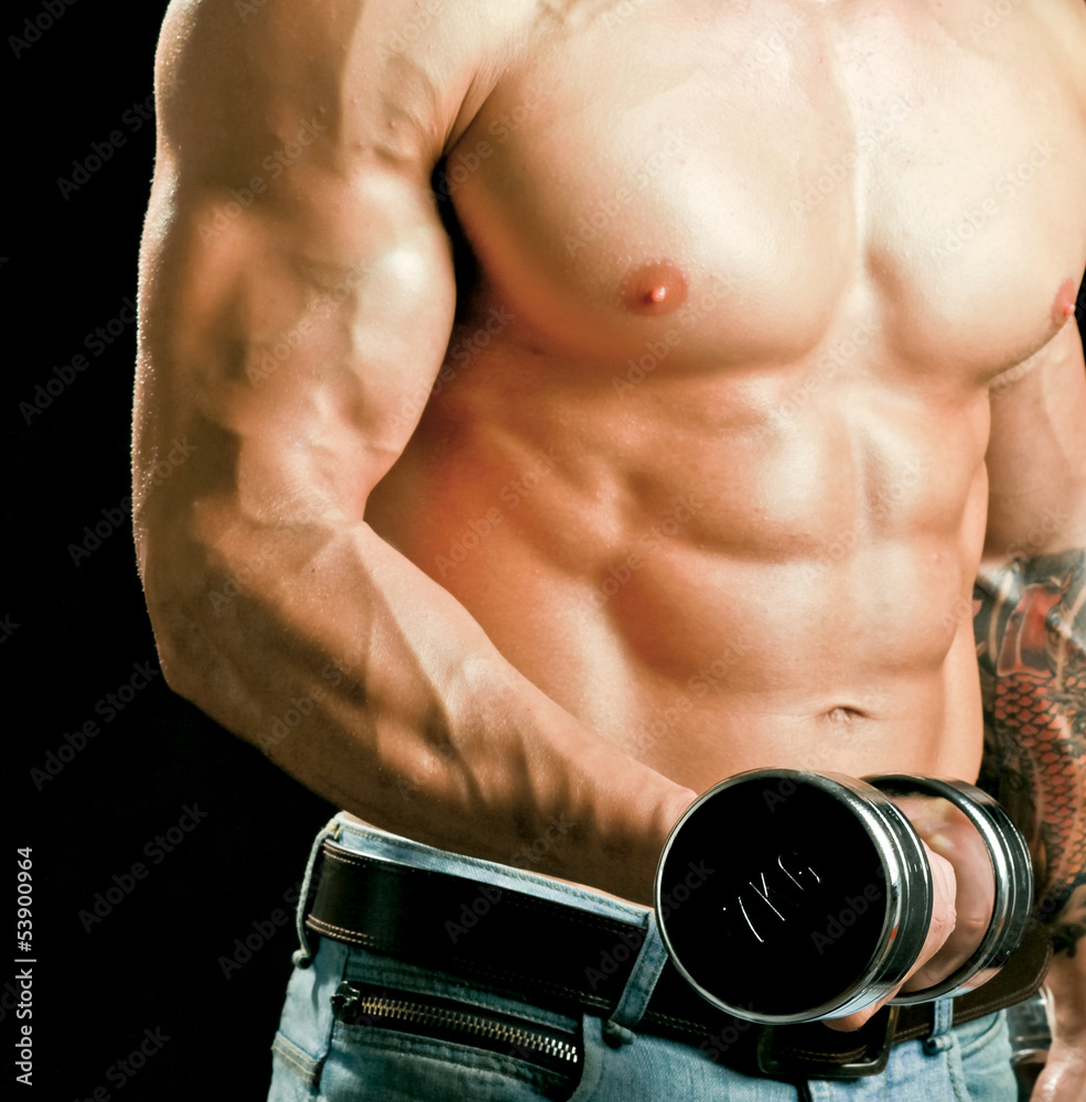 Naklejka premium Handsome muscular man working out with dumbbells