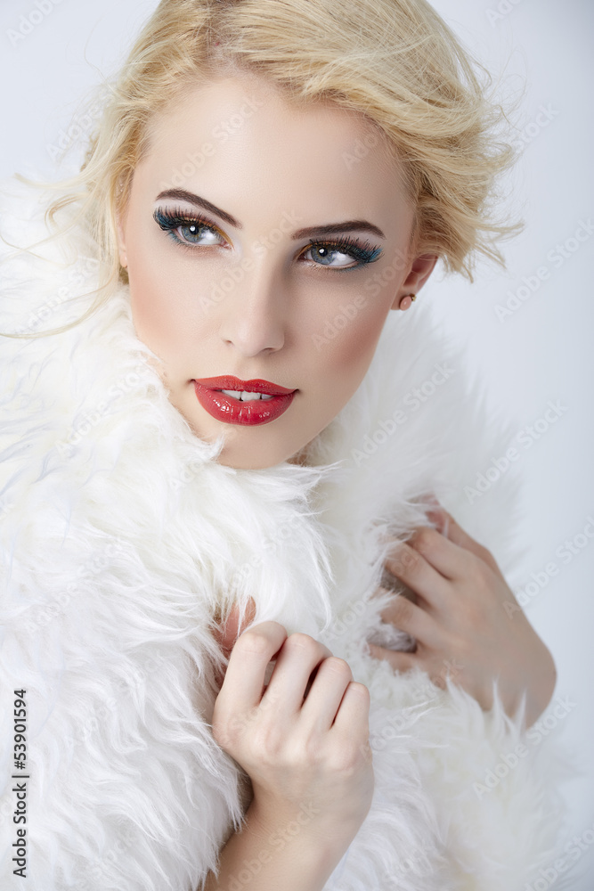 Stylish blonde woman posing in white fur