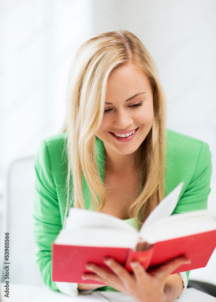 smiling young woman reading book at school smiling young woman reading book at school