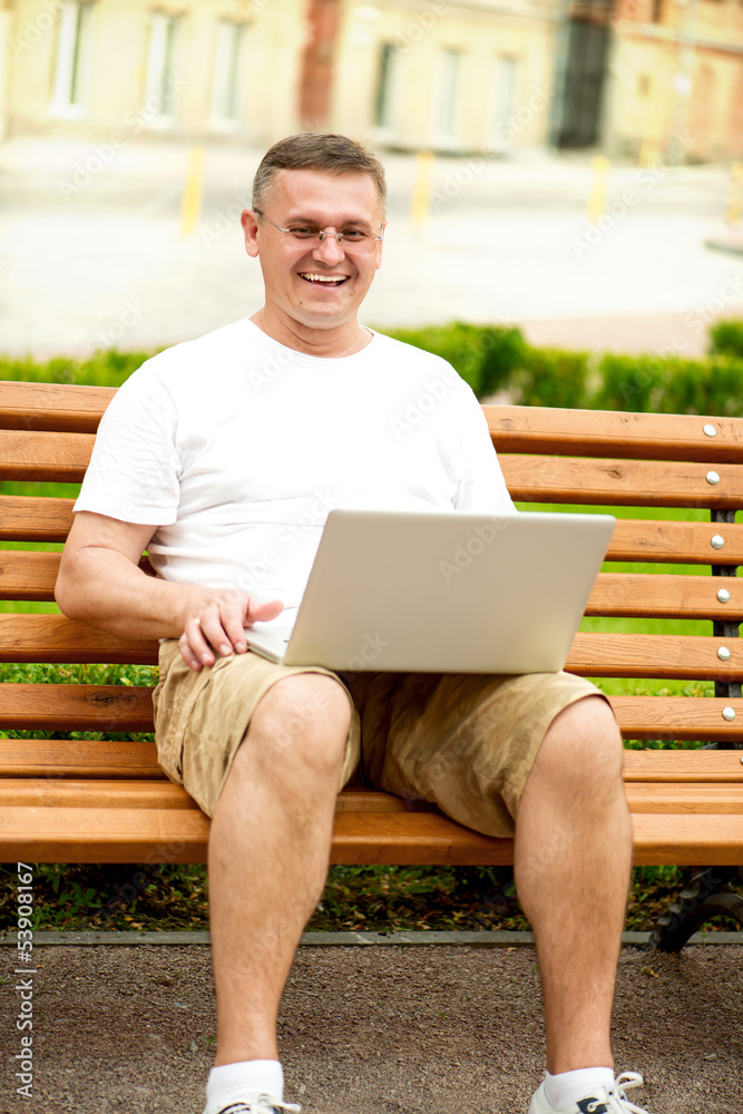 Man with laptop sitting on bench Man with laptop sitting on bench