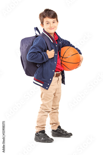Full length portrait of a schoolboy with backpack holding a bask