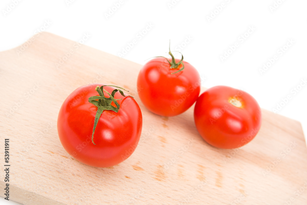 Three red tomatoes on the wooden background Three red tomatoes on the wooden background