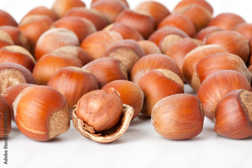 peeled hazelnut among unpeeled, isolated on white background peeled hazelnut among unpeeled, isolated on white background