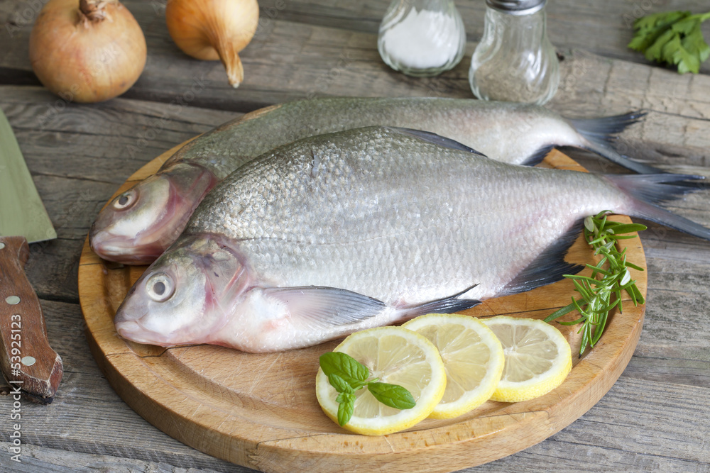 Bream raw fish on cutting board in the kitchen with spices Bream raw fish on cutting board in the kitchen with spices