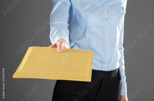 Businesswoman reaching out letter in yellow envelope
