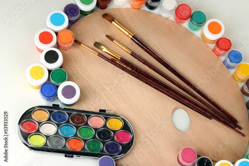 Wooden art palette with brushes for painting and paints