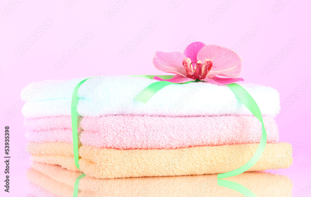 Towels tied with ribbon on light pink background Towels tied with ribbon on light pink background