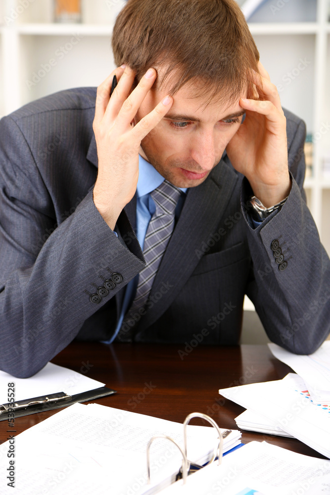 Young businessman in office at his workplace Young businessman in office at his workplace