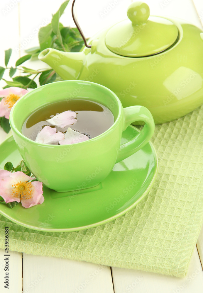 Cup and teapot of herbal tea with hip rose flowers Cup and teapot of herbal tea with hip rose flowers
