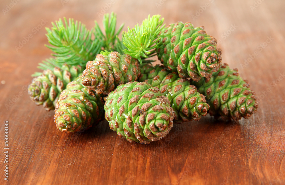 Green cones and fir tree on wooden background Green cones and fir tree on wooden background