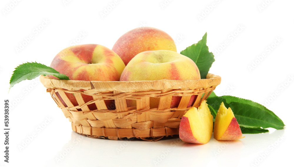 Ripe sweet peaches with leaves in basket, isolated on white Ripe sweet peaches with leaves in basket, isolated on white