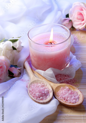 Beautiful candle with flowers on white cloth  close up