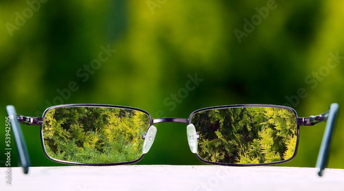 Eyeglasses on green nature background