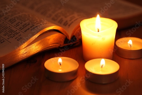 Close-up of candles and open Bible..