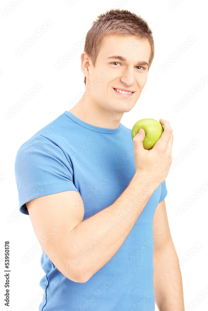 Handsome young man posing with a green apple in his hand Handsome young man posing with a green apple in his hand