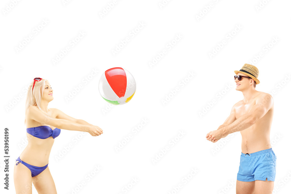 Young male and female in swimwear playing with a beach ball
