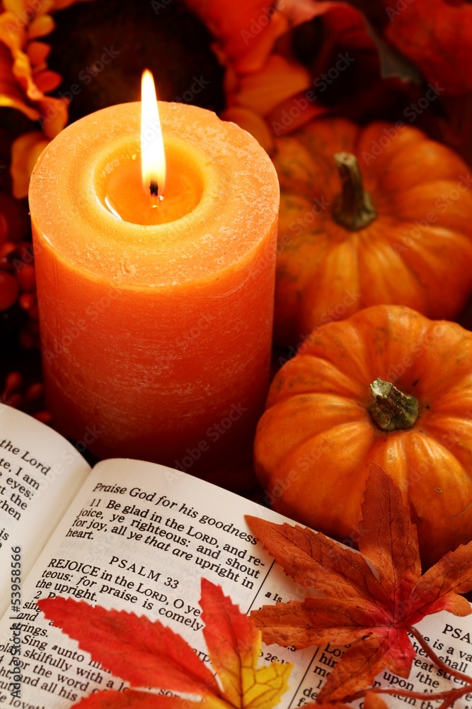 Fototapeta premium Open Bible, candle, and autumn decorations.