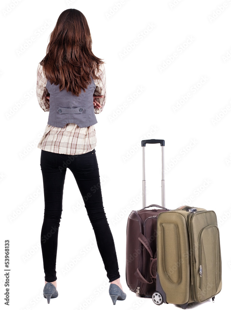 Back view of traveling brunette woman in jeans with suitcase loo Back view of traveling brunette woman in jeans with suitcase loo