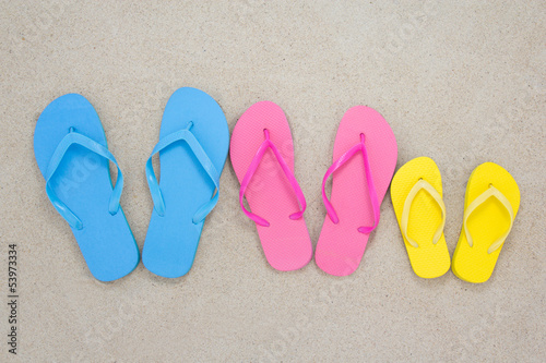 colorful flip flops on sandy beach