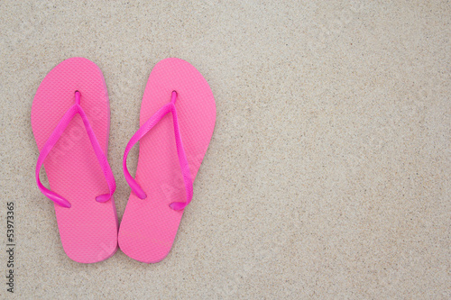 red flip flops on the white sand of a tropical beach