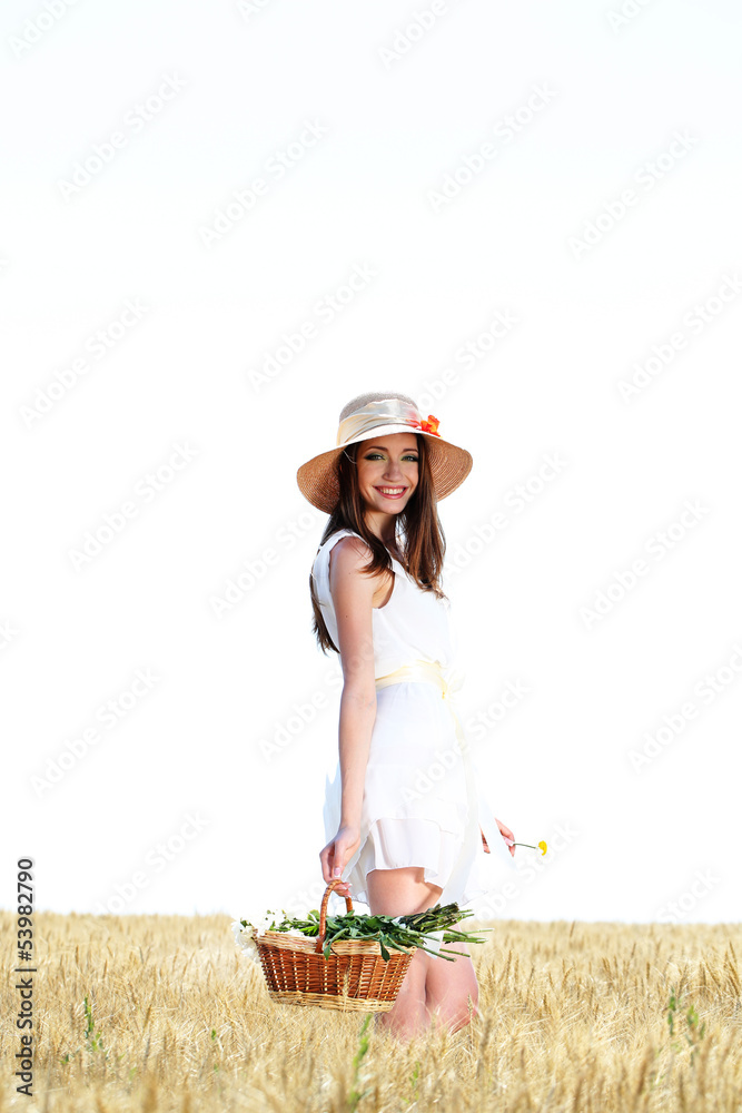 Obraz premium Portrait of beautiful young woman with flowers in the field