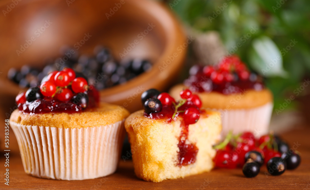 Tasty muffins with berries on wooden table