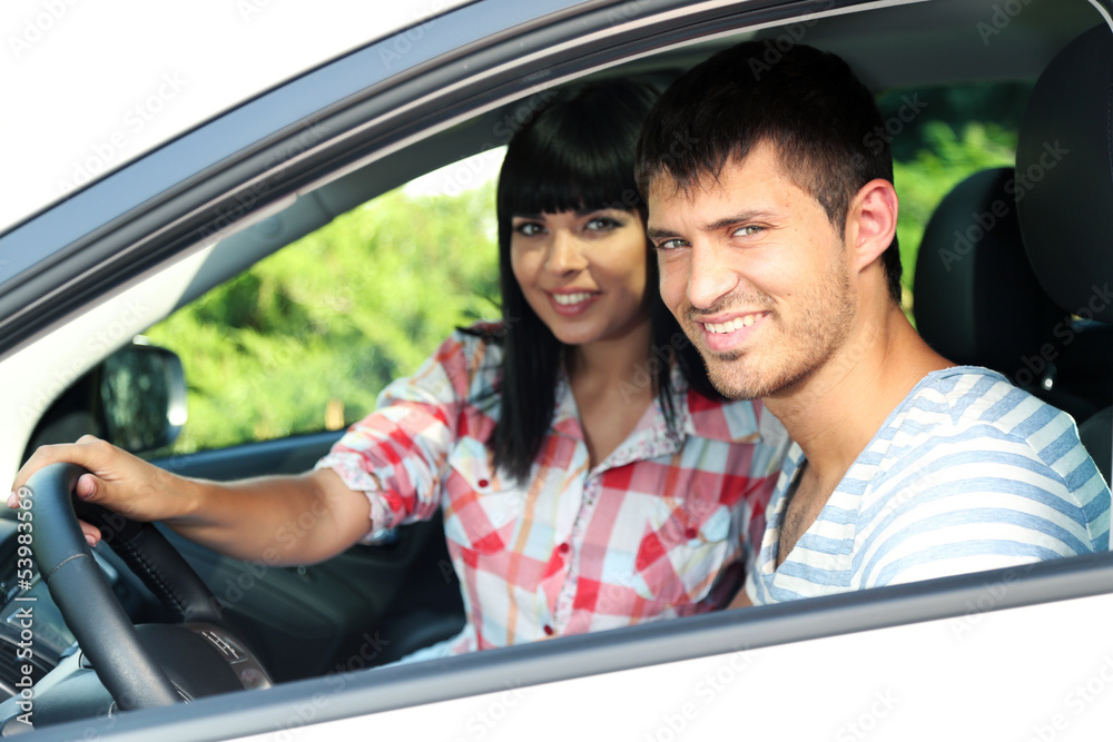 Beautiful happy young couple driving car Beautiful happy young couple driving car