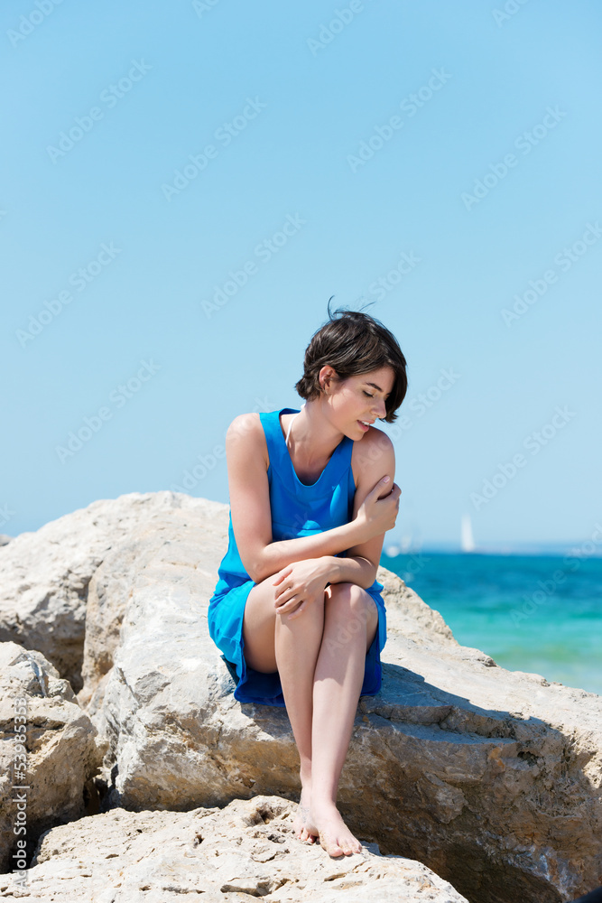frau mit heller haut sitzt in der sonne am meer frau mit heller haut sitzt in der sonne am meer