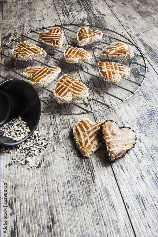 Fototapeta premium Cookies whith sesame in the shape of heart on the metal grille