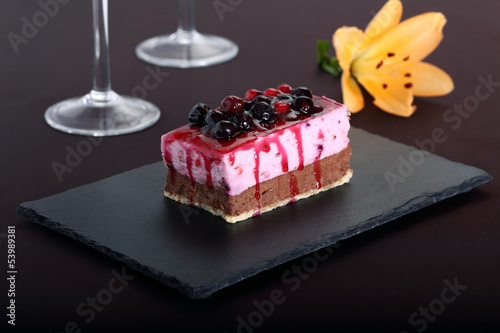 dessert con frutti di bosco su pietra nera sfondo porpora