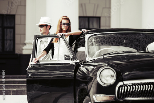 Young couple with a retro car © Wrangler