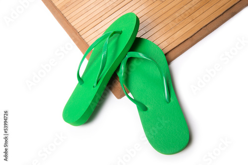Green Flip Flops on Bamboo Mat