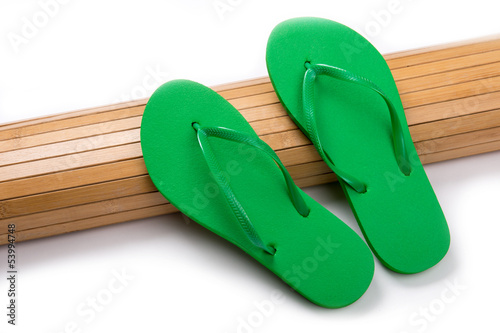 Green Flip Flops on Bamboo Mat With Copy Space