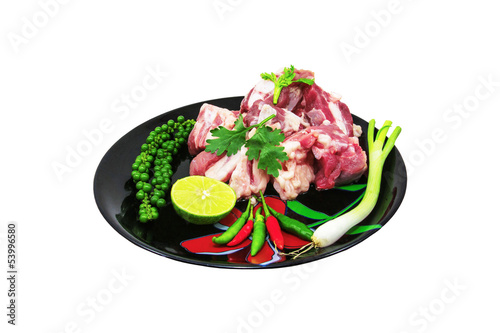 Raw pork ribs on a cutting board and vegetables photo
