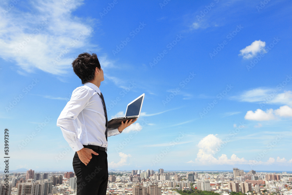 business man with laptop and look sky and cloud