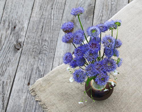 Rustic still life with a bouquet of blue flowers on a wooden bac photo