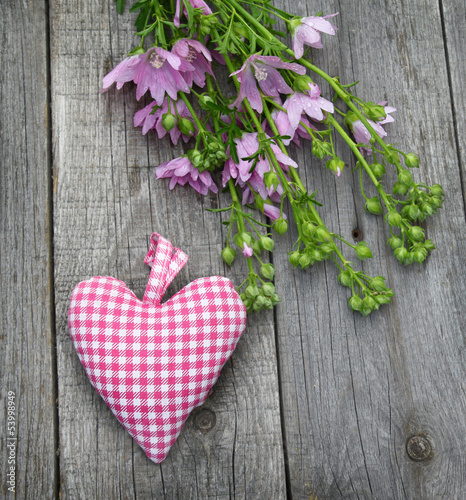 Rustic still life with a bouquet of mallow and heart on a wooden photo