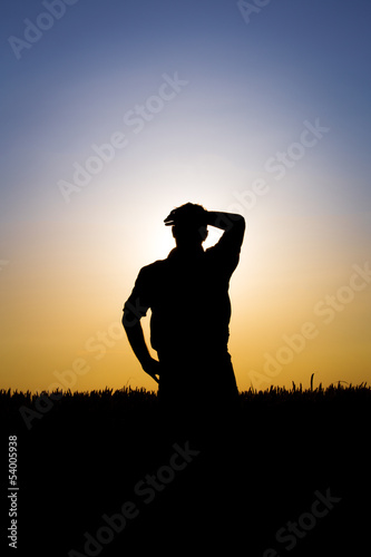 farmer in a field of wheat in the sunset