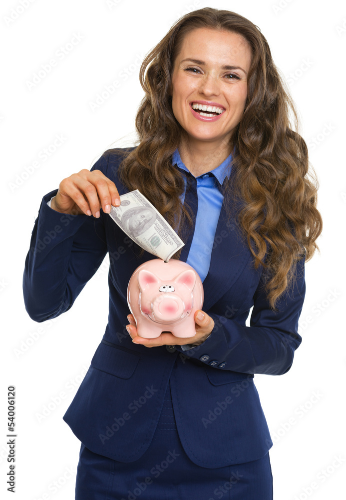 Business woman putting 100 dollars banknote into piggy bank Business woman putting 100 dollars banknote into piggy bank