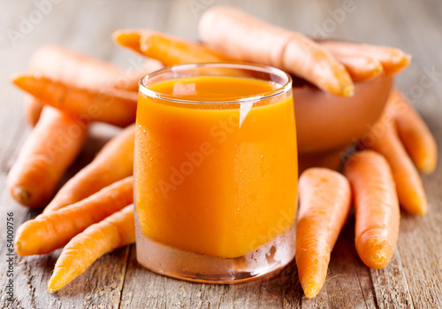 glass of carrot juice with fresh carrots photo