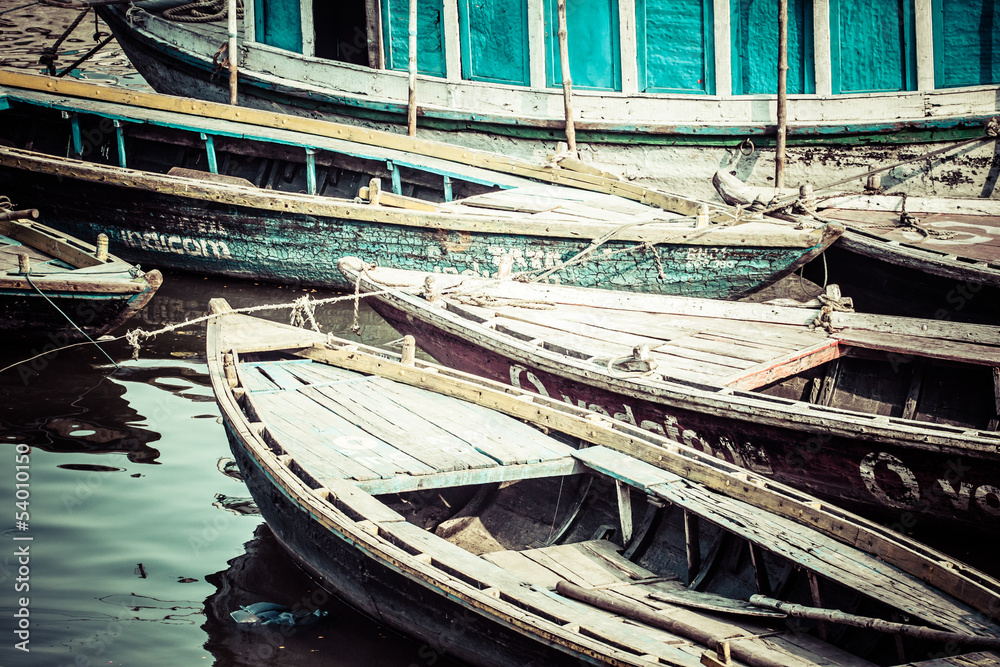 Old boats on brown waters of Ganges river, Varanasi, India Old boats on brown waters of Ganges river, Varanasi, India