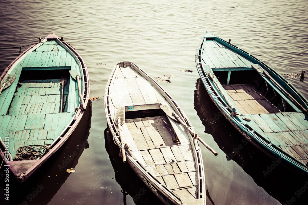 Old boats on brown waters of Ganges river, Varanasi, India Old boats on brown waters of Ganges river, Varanasi, India