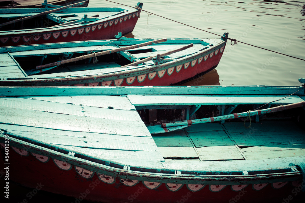 Old boats on brown waters of Ganges river, Varanasi, India