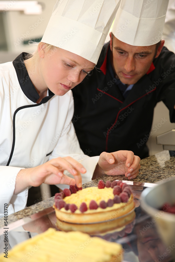 Pastry cook teaching student to make a cake Pastry cook teaching student to make a cake